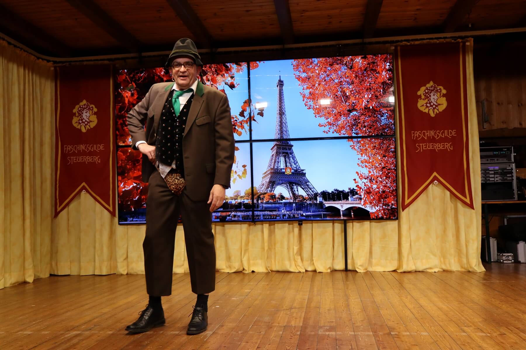 Solodarsteller auf der Bühne vor einer Paris-Kulisse